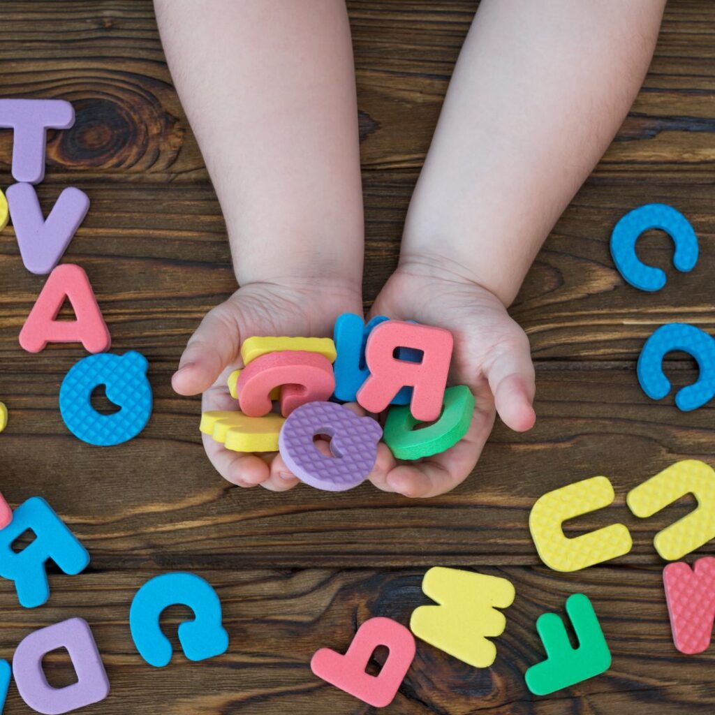 Mani di bambino tengono lettere inglesi